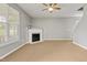 Cozy living room with a fireplace, ceiling fan and large window at 524 Woodson Dr, Clayton, NC 27527