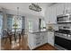 Modern kitchen with white cabinets, stainless steel appliances, and a kitchen island with granite countertops at 535 W Holding Ave, Wake Forest, NC 27587