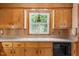 Traditional kitchen featuring wood cabinetry, laminate countertops, and a window overlooking the backyard at 5652 Laurel Crest Dr, Durham, NC 27712