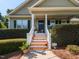 Close-up of the home's entrance with a charming porch, decorative plants, and inviting stairway at 70 King Mackeral Ct, Willow Springs, NC 27592