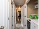 Hallway laundry area with a modern washer and dryer, overhead shelving, and ample storage space at 70 King Mackeral Ct, Willow Springs, NC 27592