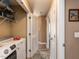 Convenient hallway laundry area equipped with a modern washing machine, dryer, and overhead storage shelves at 70 King Mackeral Ct, Willow Springs, NC 27592