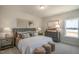 Comfortable bedroom featuring a cozy bed, neutral decor, decorative lamps, and woven stools at the foot of the bed at 702 Beacon Hill Rd # 51, Lillington, NC 27546