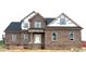 New construction two-story home featuring brick facade, white door and window frames, and a dark roof at 7491 Sweetwater Dr, Nashville, NC 27856