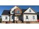 New two-story home construction featuring brick facade, white door and window frames, and a dark roof at 7491 Sweetwater Dr, Nashville, NC 27856