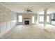 Bright, spacious living room with a fireplace, ceiling fan and wainscoting, ready for personalization at 7491 Sweetwater Dr, Nashville, NC 27856