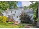 Landscaped backyard with white siding, wooden deck, and verdant lawn creates a private outdoor oasis at 7804 Tylerton Dr, Raleigh, NC 27613