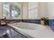 Bathroom with a jetted tub, large windows, and natural light at 7804 Tylerton Dr, Raleigh, NC 27613