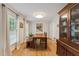 Bright dining room with wood table, bench seating, hardwood floors, and decorative lighting at 7804 Tylerton Dr, Raleigh, NC 27613