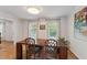 Dining room with wood table, hardwood floors, natural light, and decorative painting at 7804 Tylerton Dr, Raleigh, NC 27613