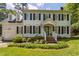 Charming two-story home with white siding, black shutters, brick entryway, and a beautifully landscaped front yard at 7804 Tylerton Dr, Raleigh, NC 27613
