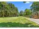 Large, level backyard, partially fenced, with mature trees and potential for gardening at 827 Loop Rd Rd, Burlington, NC 27217