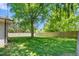Expansive backyard featuring lush green grass, mature trees, and a wooden privacy fence at 827 Loop Rd Rd, Burlington, NC 27217