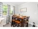 Cozy dining area featuring a wooden table set for a meal and natural light streaming through the windows at 827 Loop Rd Rd, Burlington, NC 27217