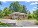 Charming home featuring a gravel driveway, two wooden decks, and light gray brick at 827 Loop Rd Rd, Burlington, NC 27217