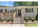 View of the entry and small porch of a brick home with manicured shrubs and a concrete walkway at 827 Loop Rd Rd, Burlington, NC 27217