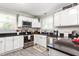 A bright kitchen featuring modern stainless steel appliances, black countertops and white cabinets at 827 Loop Rd Rd, Burlington, NC 27217