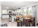 Bright kitchen featuring white cabinets, black countertops, a dining table, and stainless steel appliances at 827 Loop Rd Rd, Burlington, NC 27217