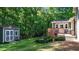 Serene backyard featuring a shed, deck, bottle tree art, and lush landscaping at 8513 Applecross Cir, Apex, NC 27539