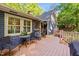 Backyard deck features seating for entertaining, with view of fenced yard and lush landscape at 8513 Applecross Cir, Apex, NC 27539