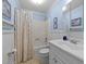 Bathroom featuring blue walls, white wainscoting, vanity sink, mirror and tub/shower combo at 8513 Applecross Cir, Apex, NC 27539
