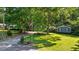 Beautiful blue home with a luscious lawn, a long driveway, mature trees, and an American flag at 8513 Applecross Cir, Apex, NC 27539