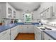 Bright kitchen boasts white cabinetry, blue countertops, stainless appliances and hardwood floors at 8513 Applecross Cir, Apex, NC 27539