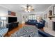 Cozy living room with hardwood floors, a ceiling fan, comfortable seating, and a large TV at 8513 Applecross Cir, Apex, NC 27539