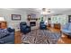 Comfortable living room with hardwood floors, a brick fireplace, blue chairs, and large patterned rug at 8513 Applecross Cir, Apex, NC 27539