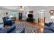 Spacious living room featuring hardwood floors, a ceiling fan, comfortable seating, and stylish furnishings at 8513 Applecross Cir, Apex, NC 27539