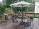 Outdoor deck featuring a table, chairs, umbrella, and various plants on a sunny day at 9009 Miranda Dr, Raleigh, NC 27617