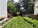 Expansive backyard showing a deck, garden, and mature trees with lush green grass at 9009 Miranda Dr, Raleigh, NC 27617