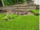 Well-maintained backyard with healthy green grass and wood barrel planters along the fence line at 9009 Miranda Dr, Raleigh, NC 27617