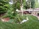 Lush backyard featuring a birdhouse, a woodpile, and decorative rock borders at 9009 Miranda Dr, Raleigh, NC 27617