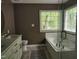 Bathroom featuring garden tub, white subway tile, and large window at 9009 Miranda Dr, Raleigh, NC 27617