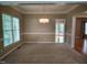 Elegant dining room featuring neutral carpet, stylish light fixture, and natural light from a window at 9009 Miranda Dr, Raleigh, NC 27617