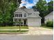 Traditional two-story home with a spacious driveway, attached garage, and a covered front porch at 9009 Miranda Dr, Raleigh, NC 27617