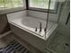 Modern soaking tub with tile surround and glass shower enclosure at 9009 Miranda Dr, Raleigh, NC 27617