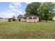 Spacious backyard view of the house, shed, and carport, surrounded by lush greenery at 1012 Roxboro St, Haw River, NC 27258