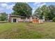 Expansive backyard featuring the house, storage shed, carport, and a utility shed at 1012 Roxboro St, Haw River, NC 27258