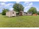 Exterior view of house, shed, carport, and lush lawn with mature trees at 1012 Roxboro St, Haw River, NC 27258