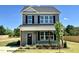 Charming two-story home with blue siding, dark shutters, covered porch, and beautifully landscaped yard at 107 Legolas Ct, Middlesex, NC 27557