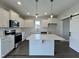 Bright kitchen boasts white cabinets, modern appliances, an island, and stylish sliding barn door at 107 Legolas Ct, Middlesex, NC 27557