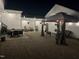 Night view of a paver patio featuring multiple seating areas illuminated by string lights at 1211 Gloriosa St, Apex, NC 27523
