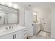 Bright bathroom featuring double sinks, white cabinetry, and elegant fixtures at 1211 Gloriosa St, Apex, NC 27523