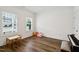 Well-lit bedroom with hardwood floors, two large windows, and a playful seating area at 1211 Gloriosa St, Apex, NC 27523