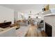 Open-concept living room with hardwood floors, fireplace, and views of the dining and kitchen areas at 1211 Gloriosa St, Apex, NC 27523