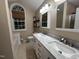 Bright bathroom featuring a double vanity with marble countertops, a large arched window, and modern fixtures at 1312 High Ridge Dr, Mebane, NC 27302