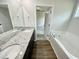 Primary bathroom featuring double sinks, granite countertops, a soaking tub, and wood flooring at 138 Sourgum Ct, Zebulon, NC 27597