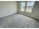 Bright carpeted bedroom with double windows looking out onto a lawn and neighboring home at 138 Sourgum Ct, Zebulon, NC 27597